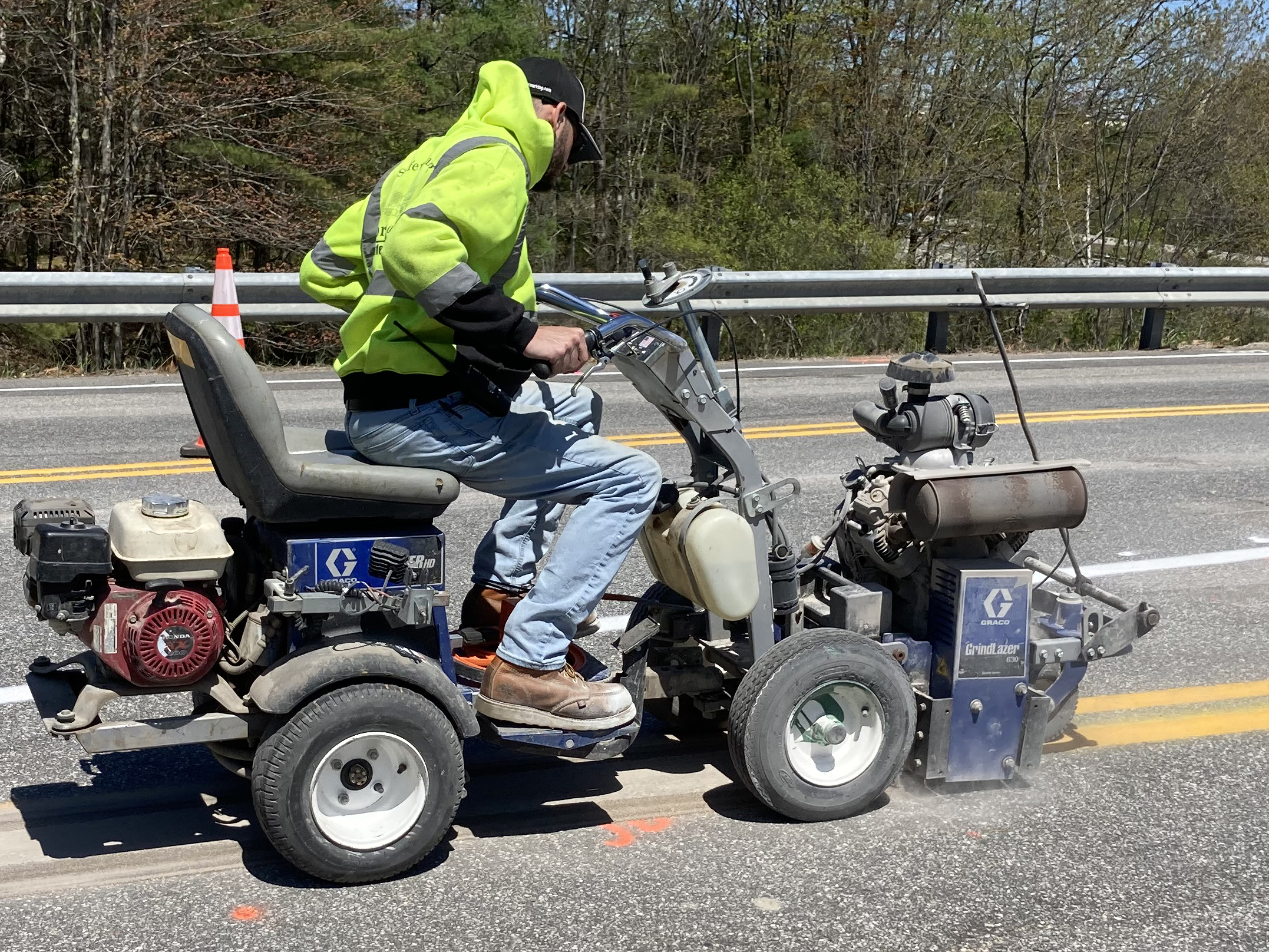 Worker on a small lane striping cart paints a new temporary lane divider.